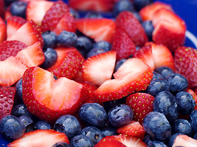 Cortar las fresas rojas mezcladas con los arándanos.