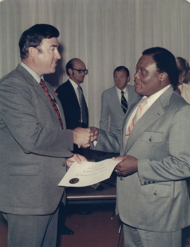 Photo of Andrew A. Best during his induction to the UNC System Board of Governors on July 7, 1972. The ceremony was held at UNC-Charlotte. Left to right: Governor Bob Scott, John Kennedy, Arch Allen, and Andrew A. Best. Image courtesy of East Carolina University and is for use in research, teaching, and private study only.  