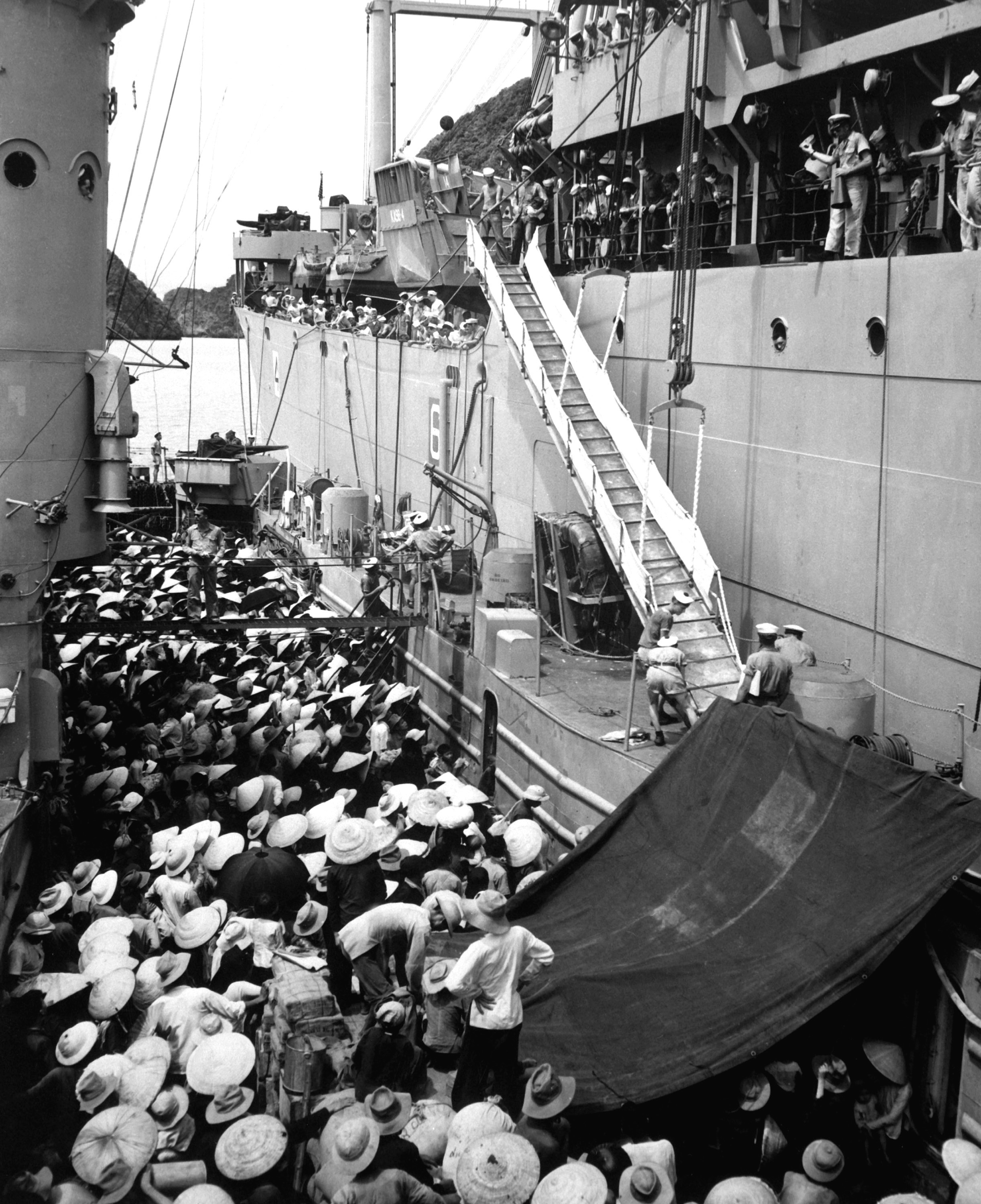 Refugees furiously convene towards boats in a harbor.