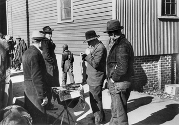 A potential customer sniffs a bottle of patent medicine offered by a street salesman in Mebane, 1939. Howard Odum Collection, no. P-3167, Southern Historical Collection, Wilson Library, UNC-Chapel Hill.